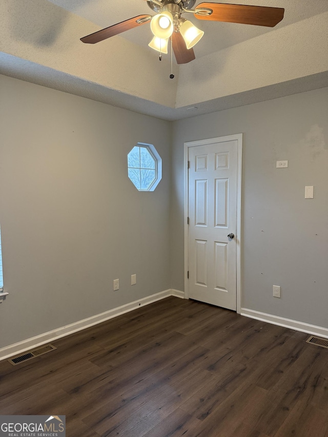 empty room featuring vaulted ceiling and dark hardwood / wood-style floors