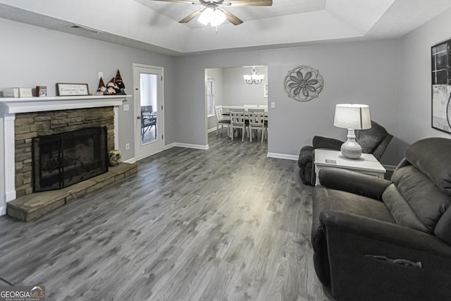 living room with a fireplace, wood-type flooring, a raised ceiling, and ceiling fan