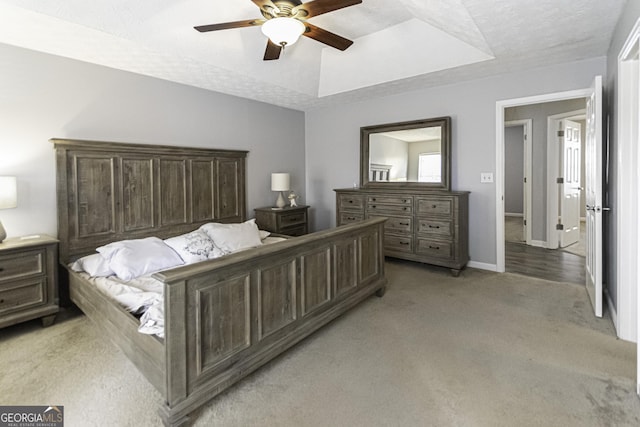 carpeted bedroom featuring ceiling fan and a textured ceiling