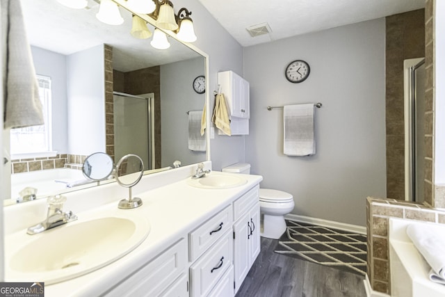 full bathroom with vanity, shower with separate bathtub, a textured ceiling, hardwood / wood-style floors, and toilet