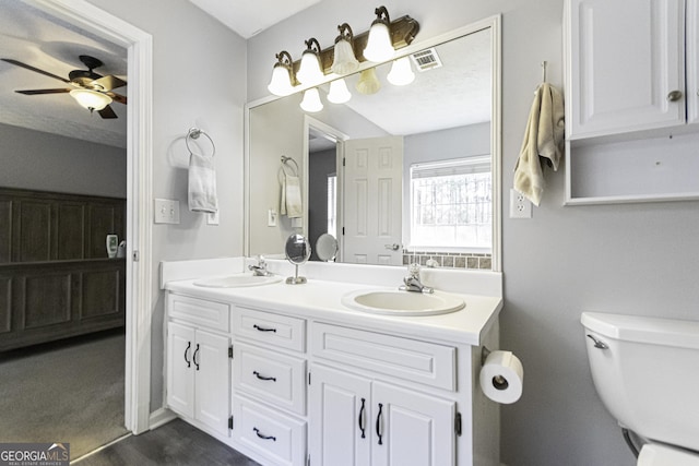 bathroom with a textured ceiling, vanity, ceiling fan, hardwood / wood-style floors, and toilet