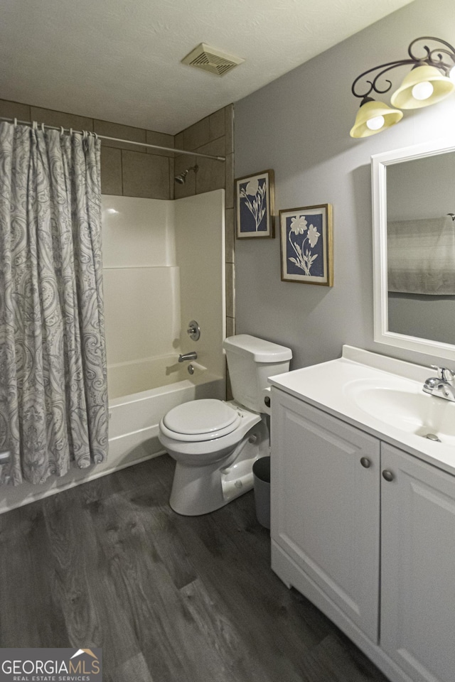 full bathroom with shower / bathtub combination with curtain, wood-type flooring, a textured ceiling, toilet, and vanity