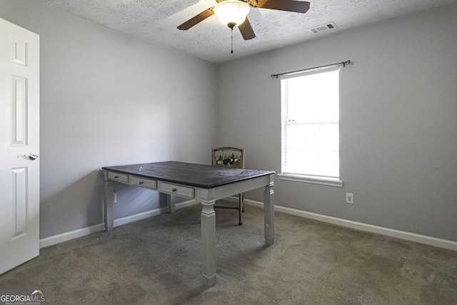 unfurnished office with ceiling fan, dark carpet, and a textured ceiling