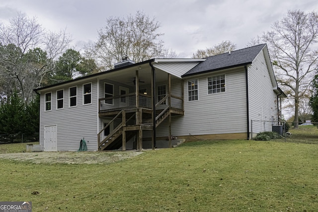 rear view of property featuring ceiling fan, a deck, a yard, and central AC