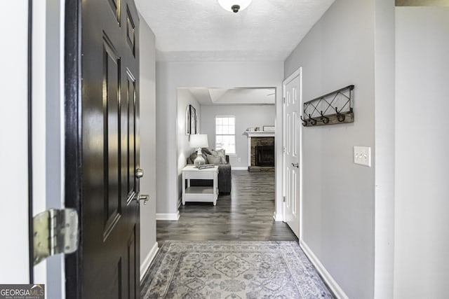 hallway featuring dark hardwood / wood-style flooring and a textured ceiling