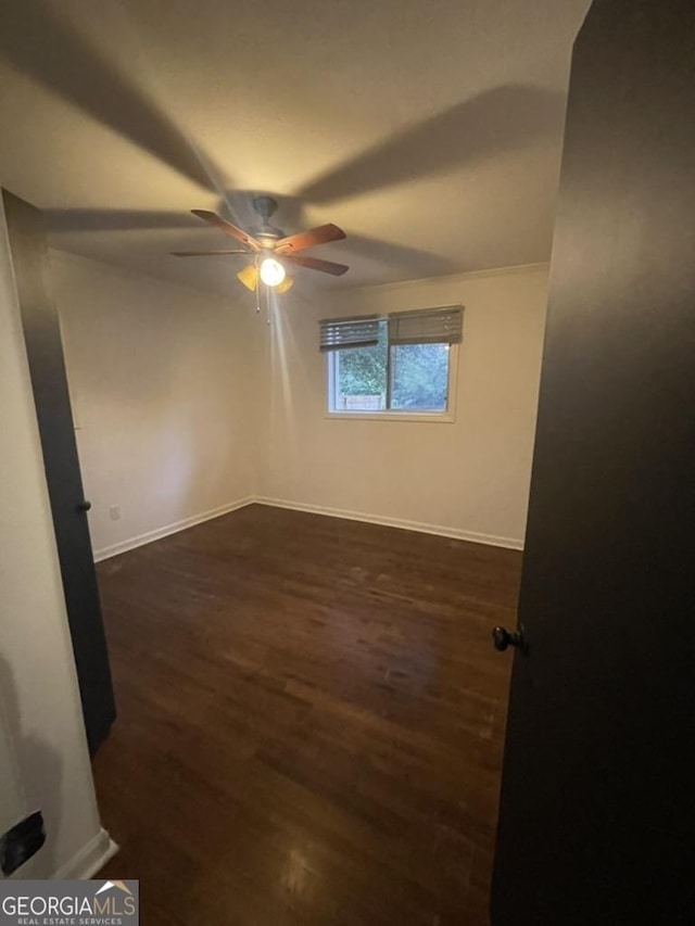 spare room with dark hardwood / wood-style floors and ceiling fan