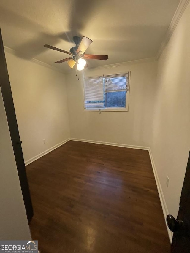 spare room featuring ceiling fan, dark hardwood / wood-style flooring, and crown molding