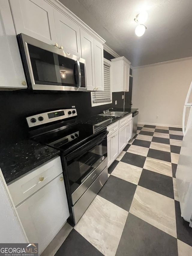 kitchen with white cabinetry, sink, stainless steel appliances, and ornamental molding