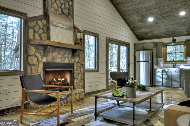 dining area with wood walls, a healthy amount of sunlight, hardwood / wood-style floors, and a chandelier