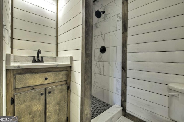 bathroom featuring wooden walls, toilet, and tiled shower