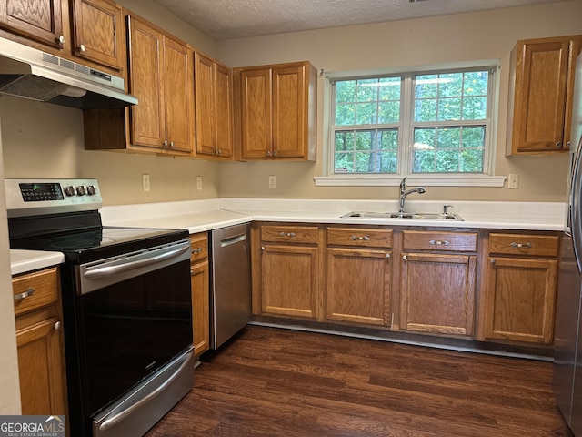 kitchen with a textured ceiling, sink, stainless steel appliances, and dark hardwood / wood-style floors