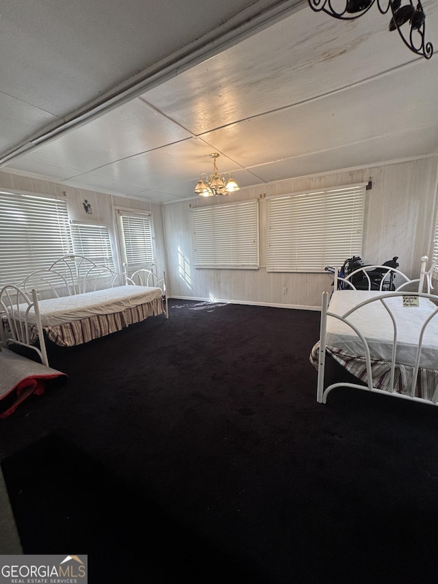 carpeted bedroom featuring a chandelier and wood walls