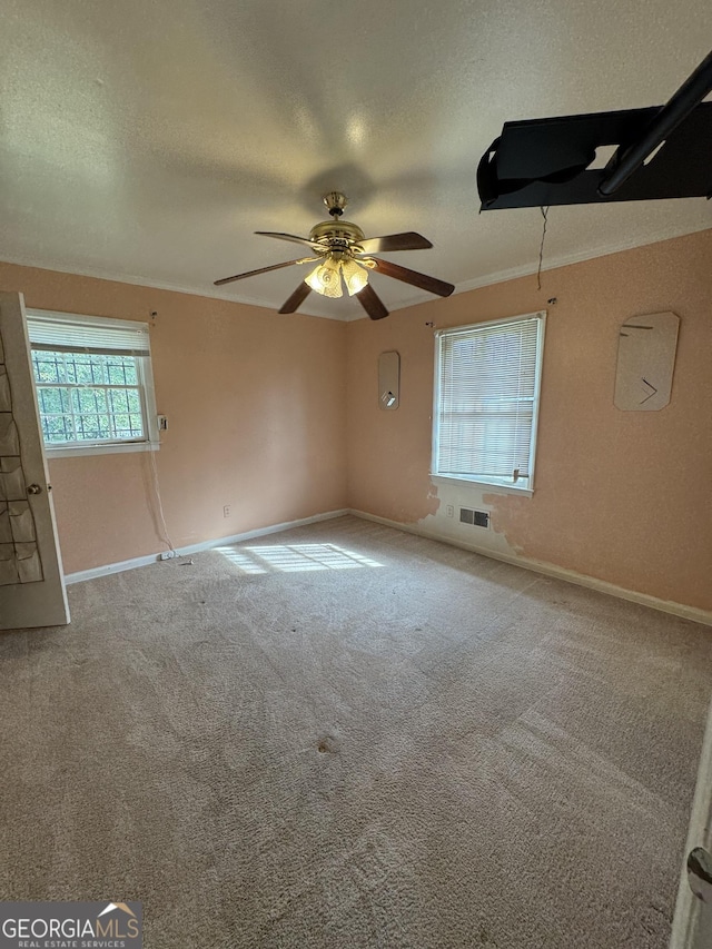 unfurnished room featuring carpet flooring, a textured ceiling, ceiling fan, and ornamental molding