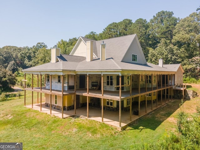 rear view of property with a patio and a lawn