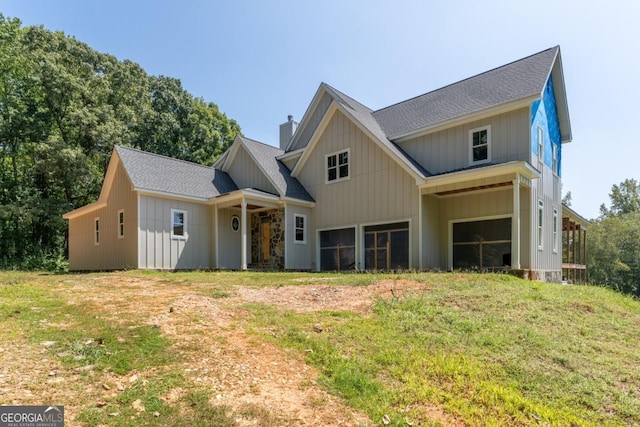 view of front of house featuring a chimney, a shingled roof, and a garage