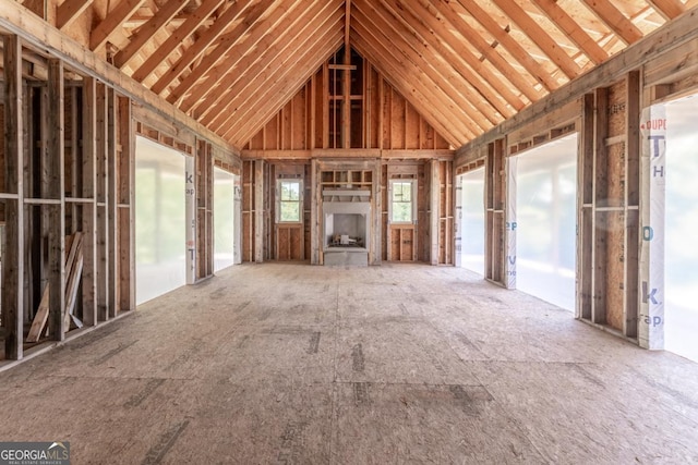 unfurnished living room featuring high vaulted ceiling