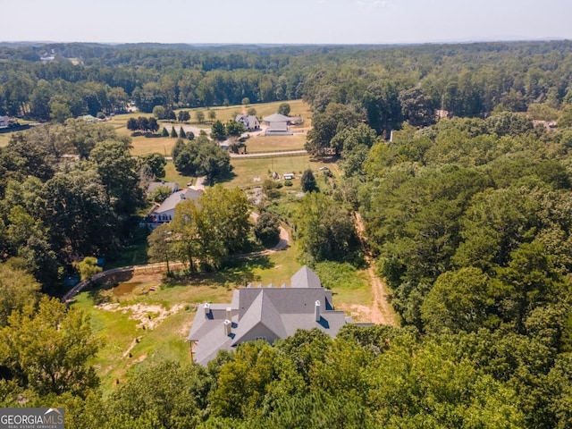 birds eye view of property featuring a forest view