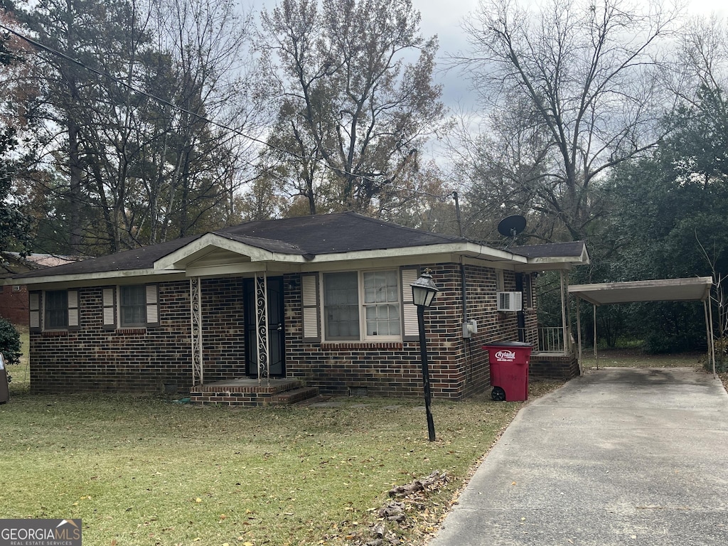 view of front of home with a front yard and a carport