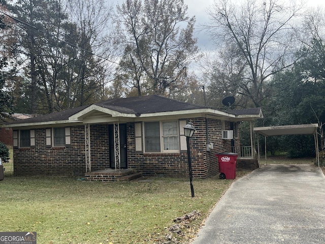 view of front of home with a front yard and a carport