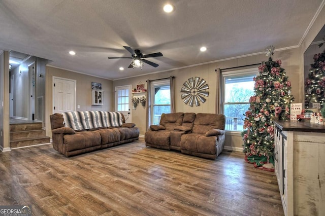 living room featuring ornamental molding, a textured ceiling, ceiling fan, wood-type flooring, and bar