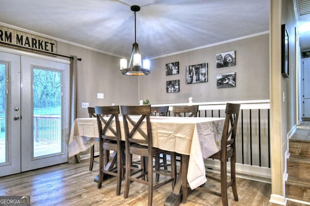 dining room with hardwood / wood-style flooring and crown molding