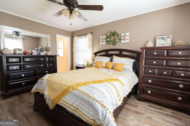 bedroom with multiple windows, ceiling fan, ornamental molding, and hardwood / wood-style flooring