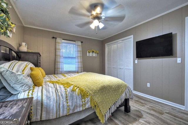 bedroom featuring a closet, hardwood / wood-style flooring, ceiling fan, and crown molding