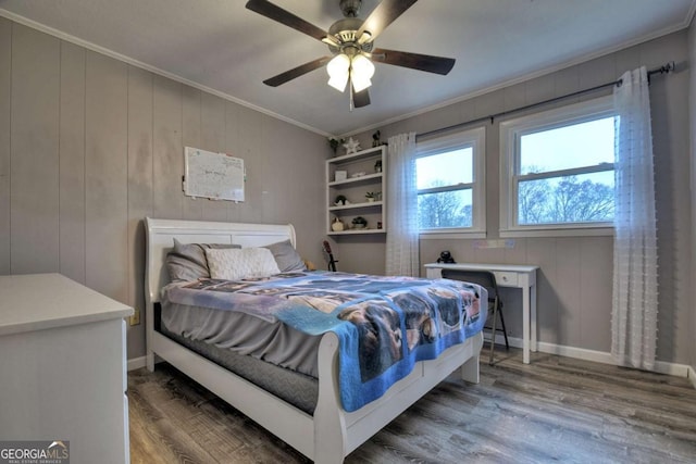 bedroom featuring hardwood / wood-style floors, ceiling fan, crown molding, and wooden walls