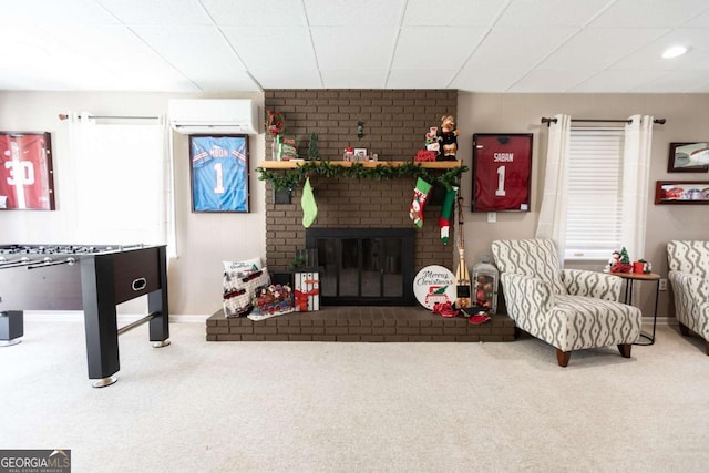 playroom with carpet flooring, an AC wall unit, and a fireplace