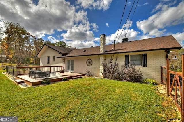 rear view of house featuring a lawn and a wooden deck