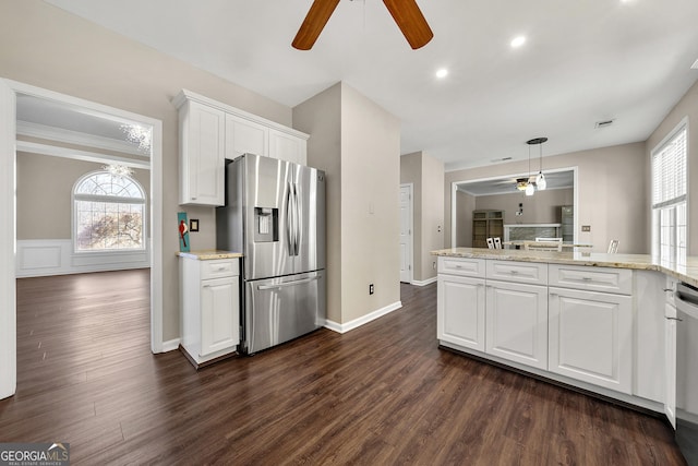 kitchen with appliances with stainless steel finishes, a healthy amount of sunlight, white cabinets, and hanging light fixtures