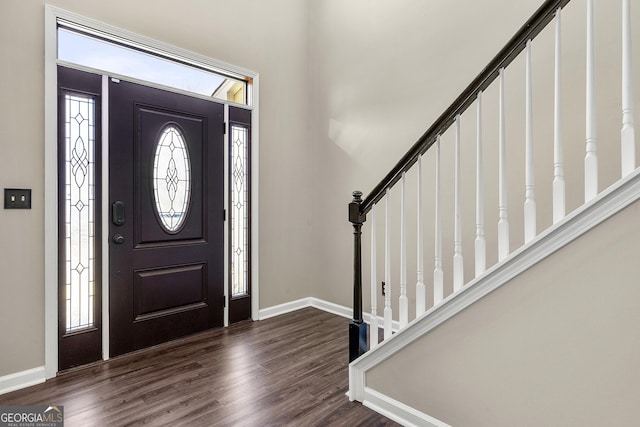 entryway with stairway, dark wood-style flooring, and baseboards