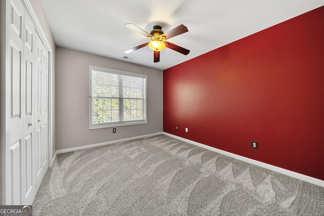 unfurnished bedroom featuring visible vents, baseboards, ceiling fan, carpet, and a closet