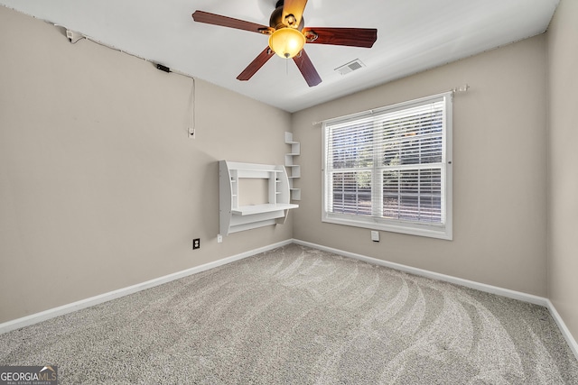 unfurnished room with carpet, visible vents, ceiling fan, and baseboards