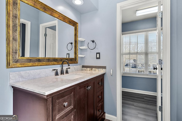 bathroom with vanity, baseboards, and wood finished floors