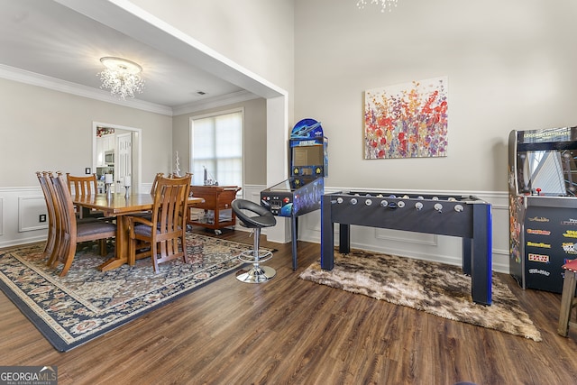 dining area with a chandelier, wood-type flooring, and crown molding