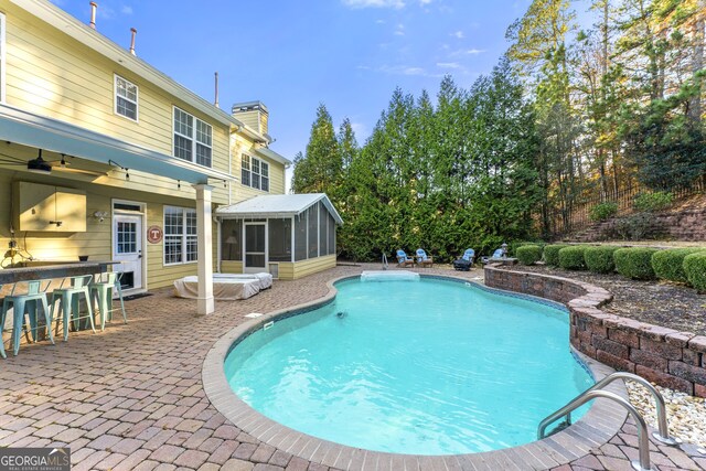 pool at dusk featuring an outbuilding and a patio