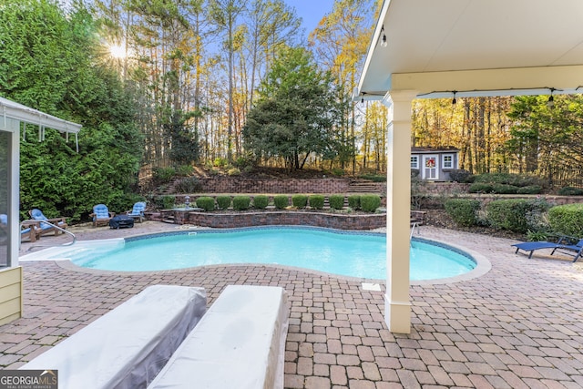 view of swimming pool with a fenced in pool, a patio, and an outbuilding