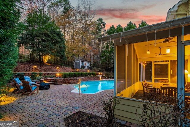 view of swimming pool with a patio area, a fenced in pool, a ceiling fan, and an outdoor structure