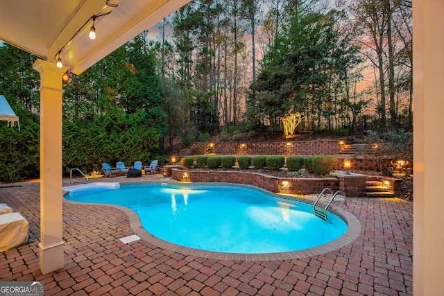 outdoor pool featuring an outdoor fire pit and a patio