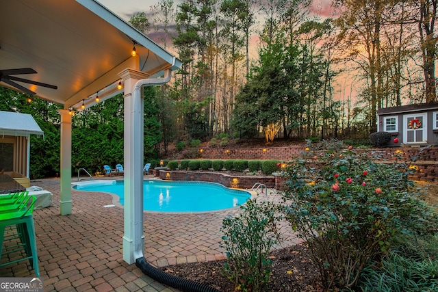 outdoor pool featuring an outbuilding, a patio area, and ceiling fan