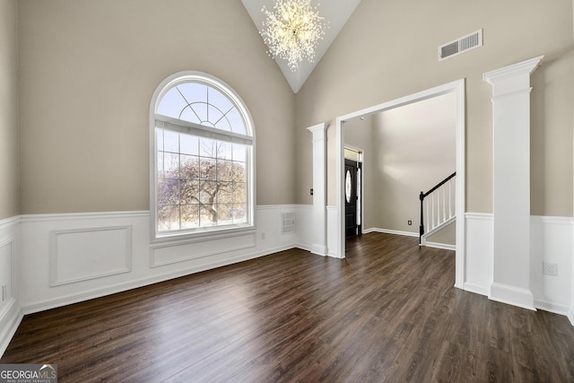 interior space with decorative columns, visible vents, a wainscoted wall, stairway, and dark wood-type flooring