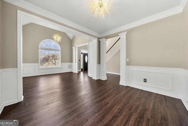 interior space featuring dark wood finished floors, vaulted ceiling, a notable chandelier, and decorative columns