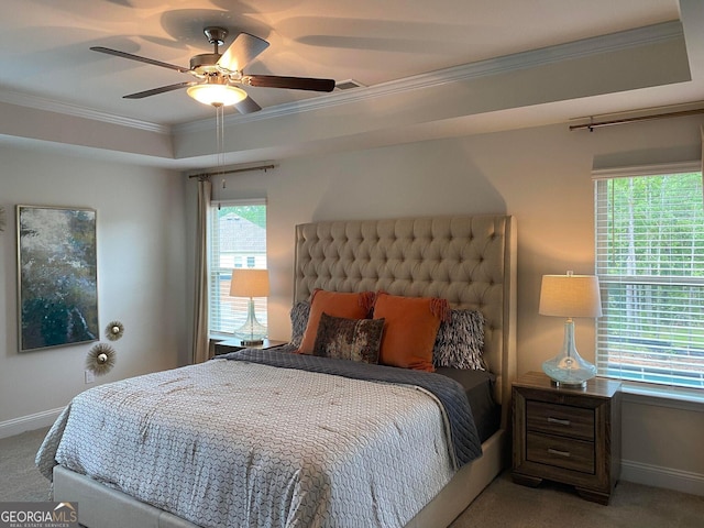 carpeted bedroom featuring ceiling fan, a raised ceiling, and crown molding