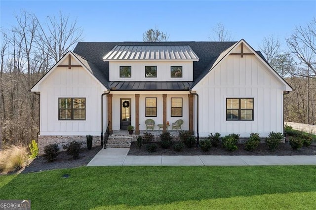 modern farmhouse featuring covered porch and a front yard