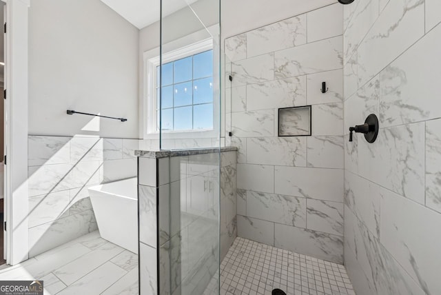 bathroom featuring a freestanding tub, tile walls, a wainscoted wall, and a tile shower