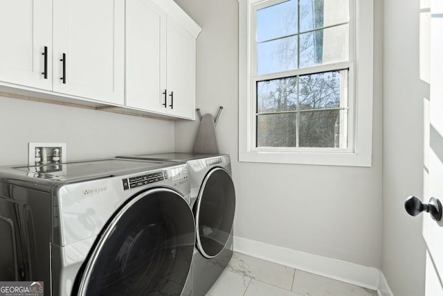 clothes washing area with washing machine and dryer, cabinet space, marble finish floor, and baseboards