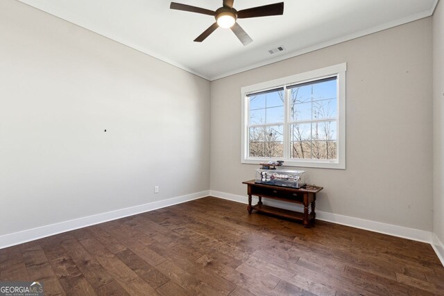 unfurnished room with visible vents, dark wood-type flooring, ceiling fan, baseboards, and ornamental molding