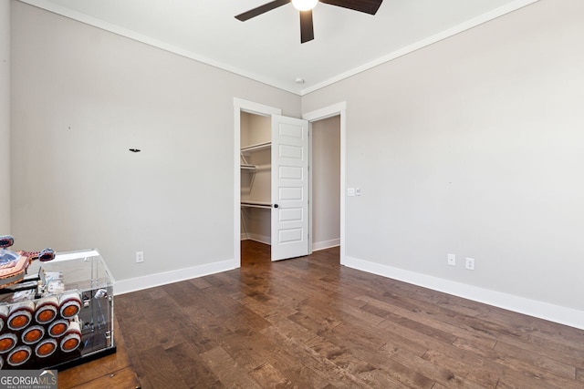 interior space featuring a ceiling fan, crown molding, wood finished floors, and baseboards