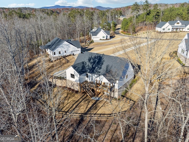 birds eye view of property with a mountain view and a wooded view